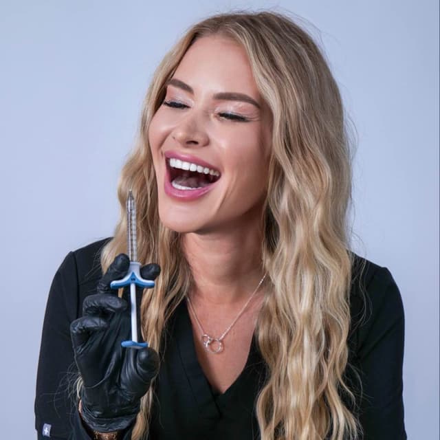 Nurse Carly smiling with a syringe